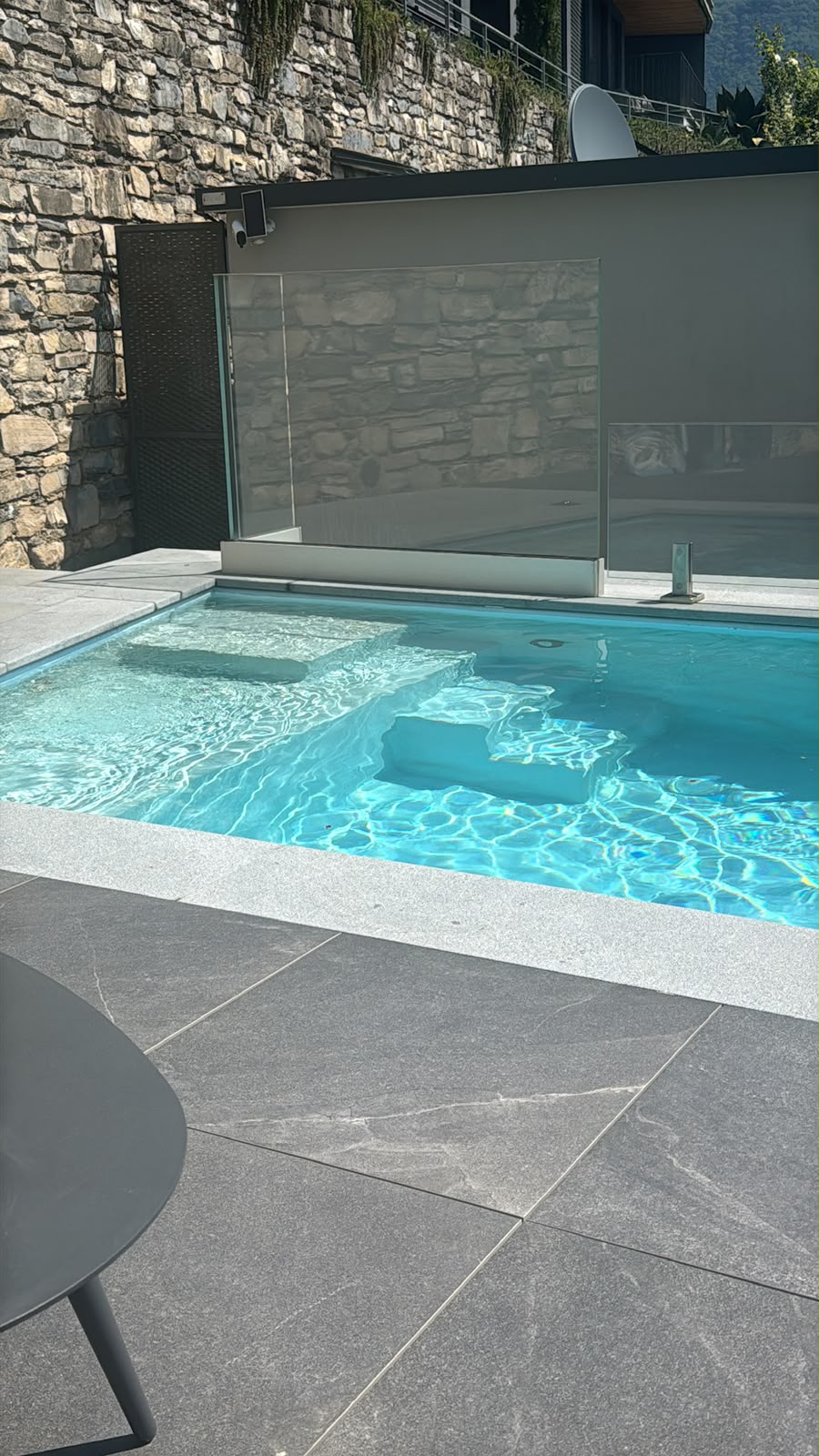 The pool as built: entry steps and grey stone paving
