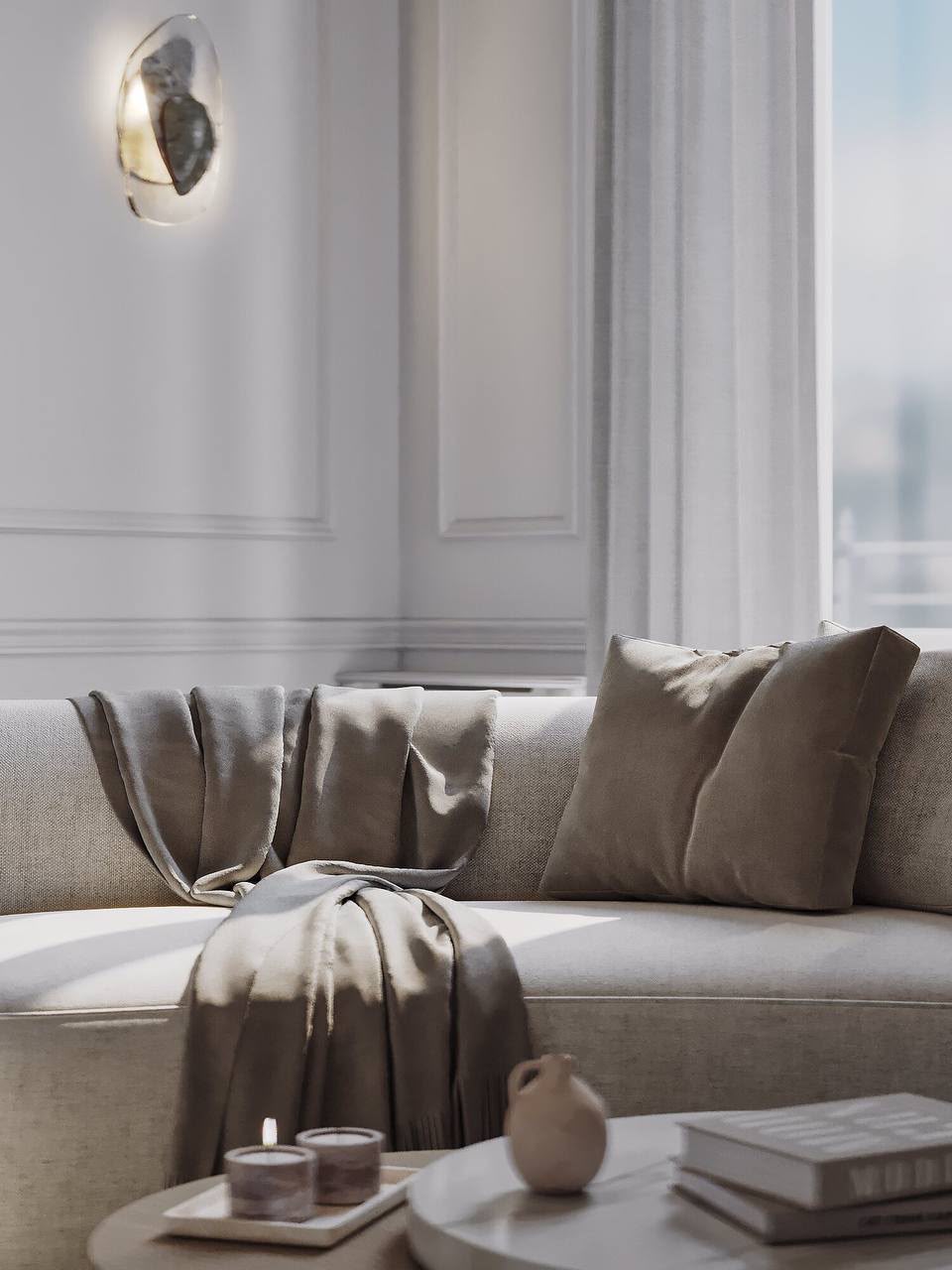 Living room: a deep sofa in linen tones under a sculptural wall light