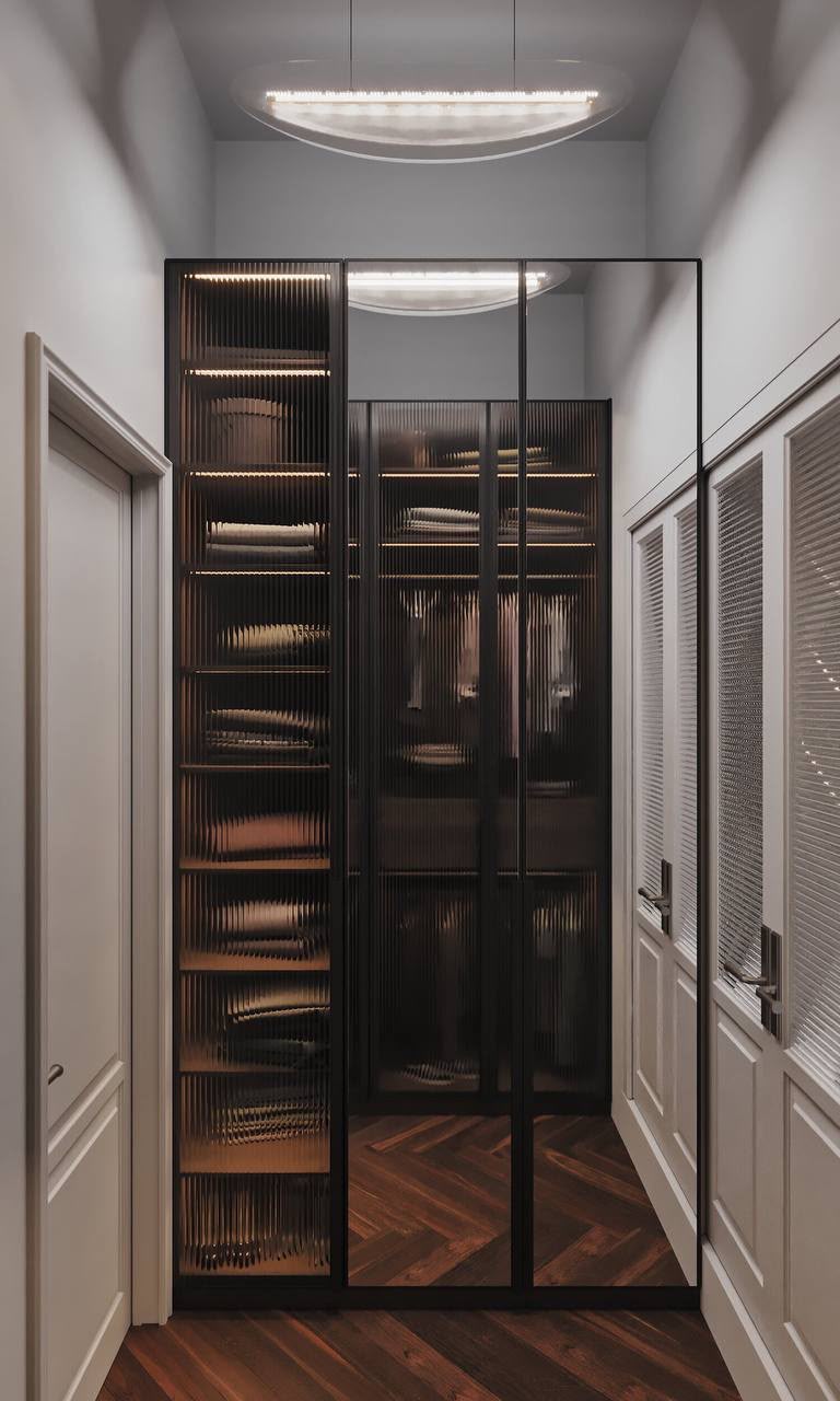 Walk-in wardrobe behind smoked-glass doors