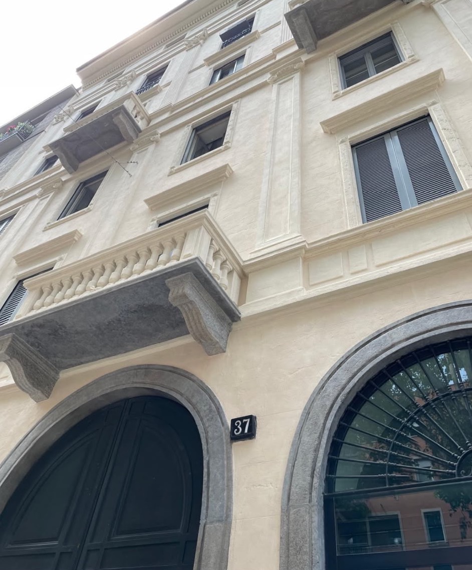 The building: stone arches and balconies on the street front