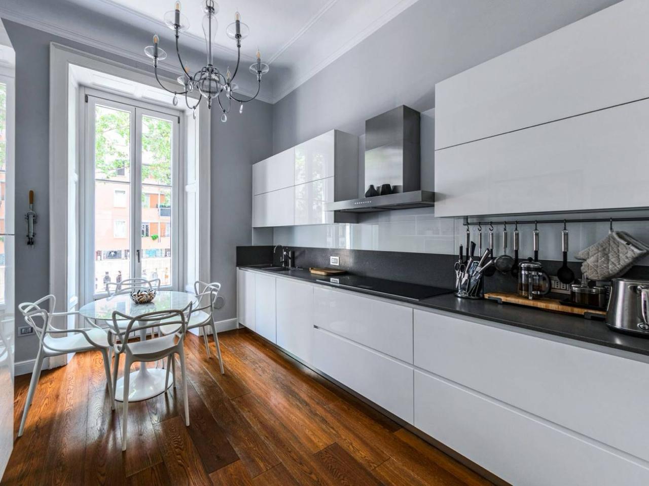Kitchen in white gloss with a dark worktop, along the French window