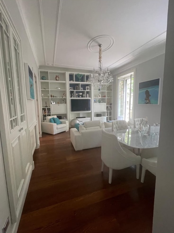 From the door: the bookcase, the sitting area and the marble dining table