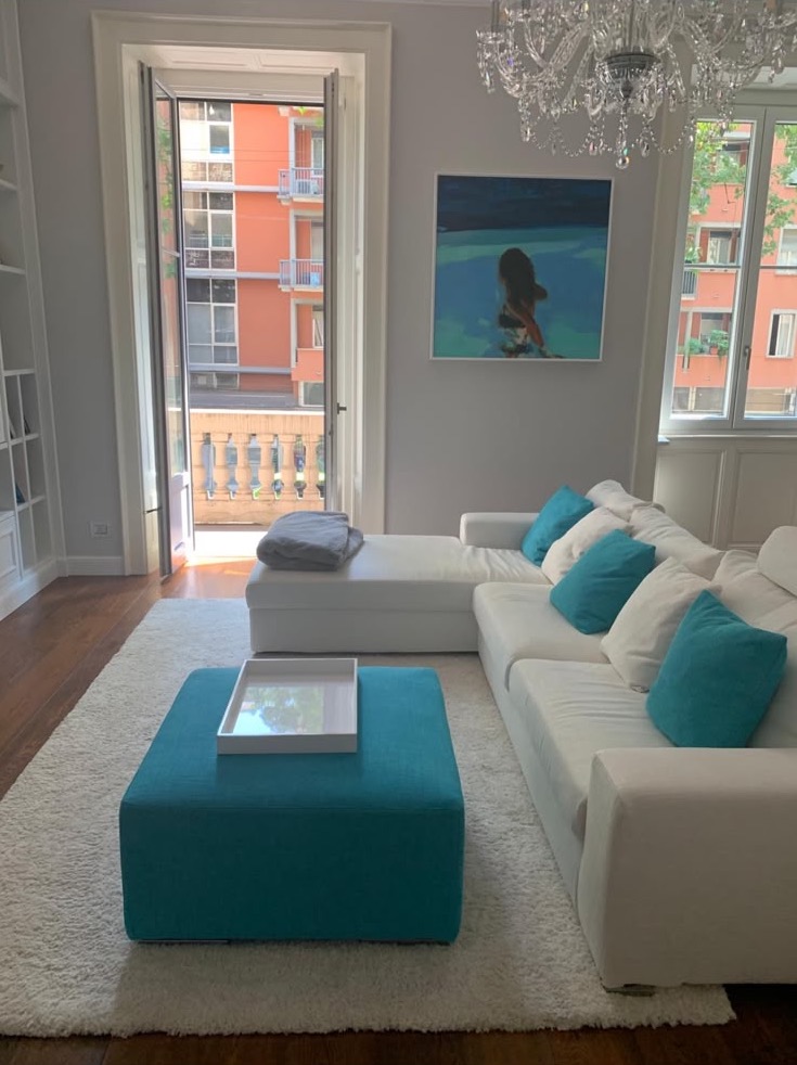 Sofa and turquoise pouf, by the balcony door