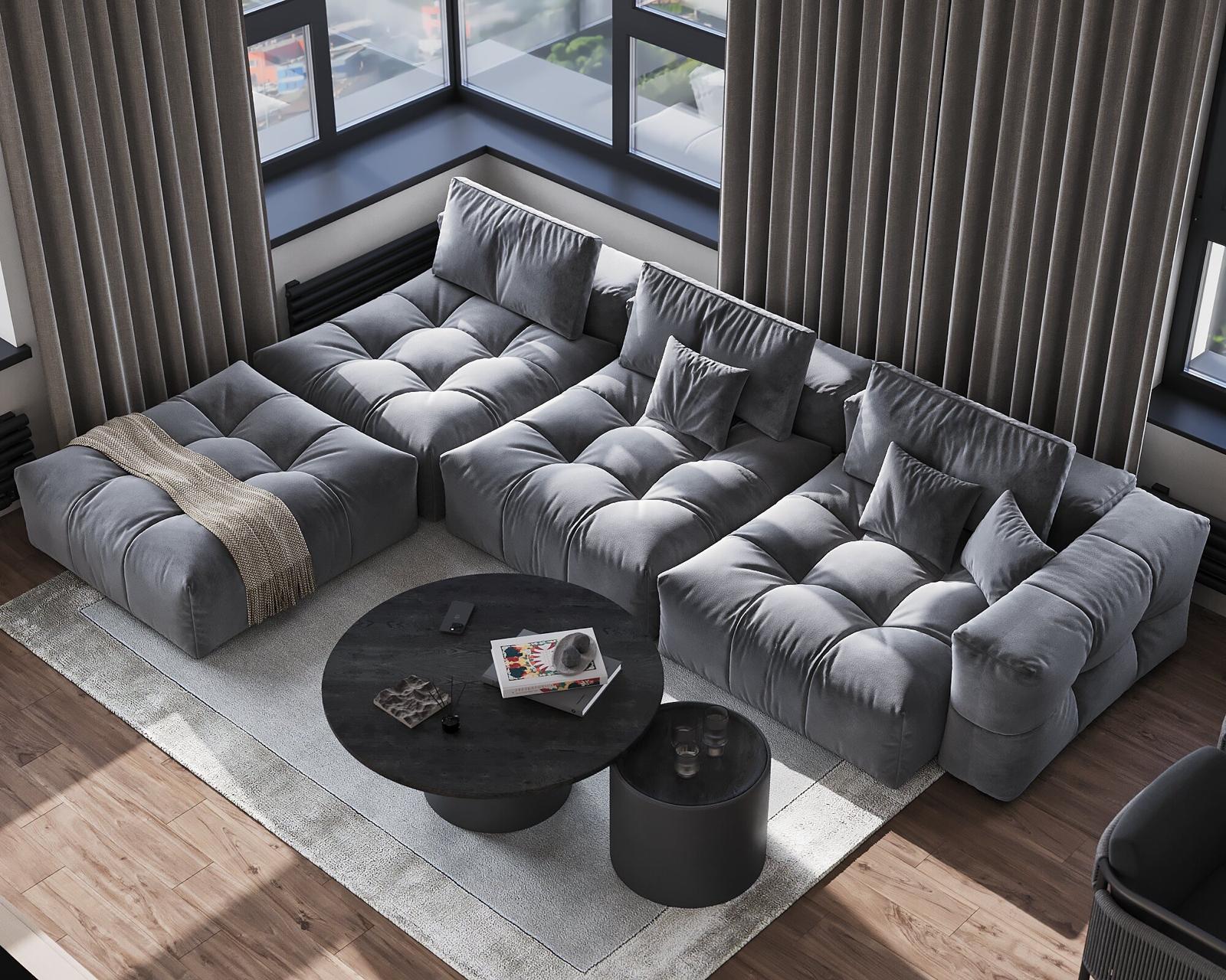 A deep quilted sofa in grey around two round black tables